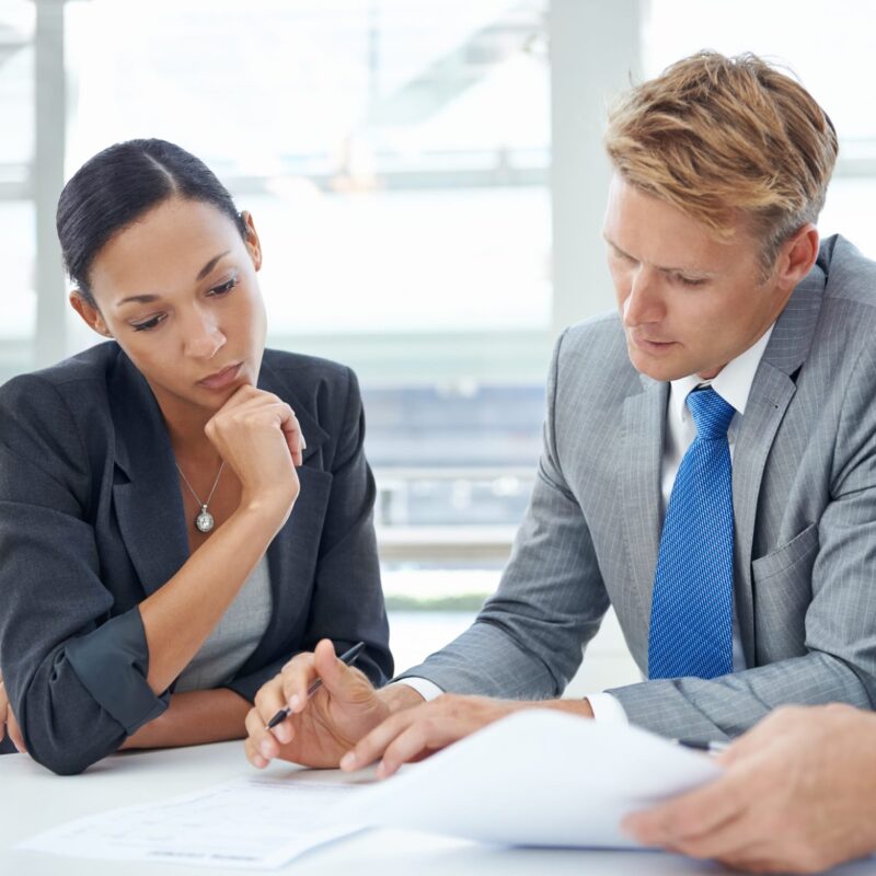 Reviewing their assets and liabilities. Shot of businesspeople looking over documents. Reviewing their assets and liabilities. Shot of businesspeople looking over documents.